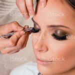 woman in a beauty salon is getting eyelash extensions done