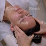 A woman in a beauty salon is getting an Indian head massage